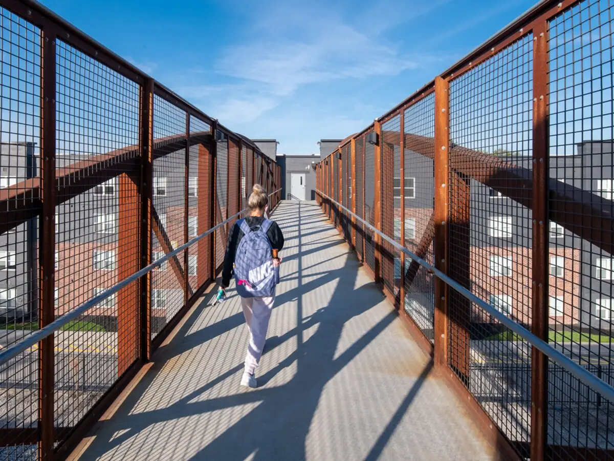 trifecta-louisville-ky-trifecta-206 Student walking across the private pedestrian bridge to the University of Louisville campus